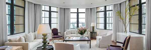 The Maybourne Beverly Hills Residence sitting room with white furniture, purple armchairs and a vase of flowers on the coffee table